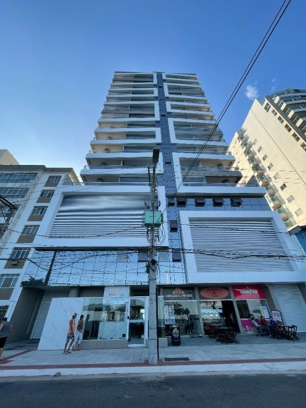 Edifício residencial alto na Praia do Morro, com a fachada da imobiliária no térreo